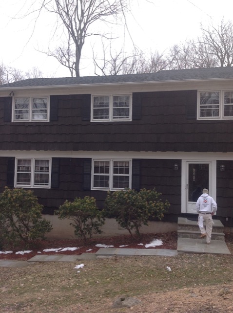 Two-storey colonial with dark brown shingles before painting