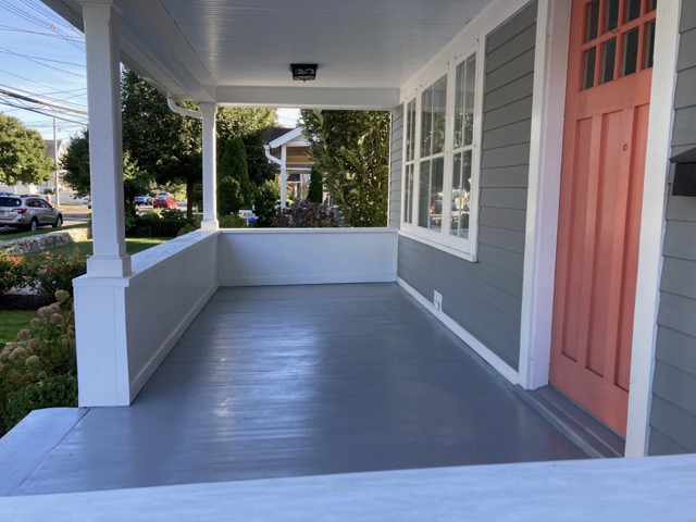 The same porch with a fresh gray floor and white railings